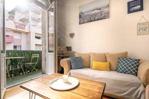 un salon avec un canapé et une table dans l'établissement Charmant appartement en centre ville, à Arcachon