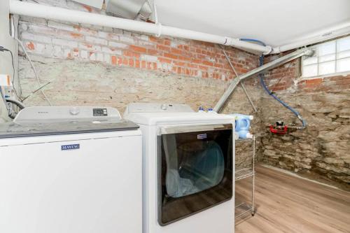 a washing machine in a room with a brick wall at Chic 4BR 3BA Historic Home Near Country Club Plaza in Kansas City