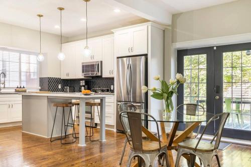 a kitchen with white cabinets and a table with chairs at Chic 4BR 3BA Historic Home Near Country Club Plaza in Kansas City