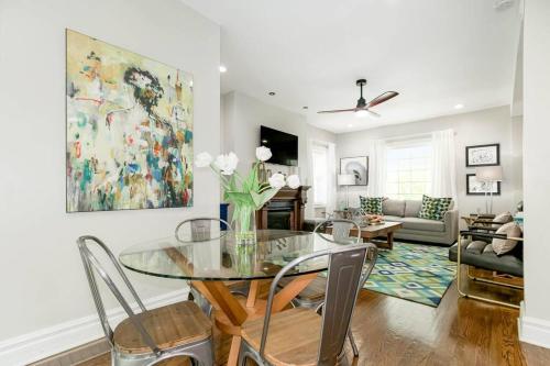 a dining room with a glass table and chairs at Chic 4BR 3BA Historic Home Near Country Club Plaza in Kansas City