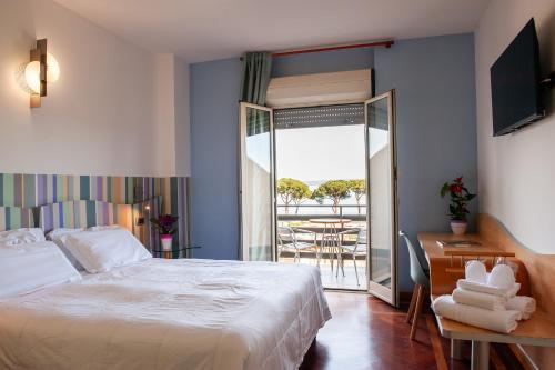 a bedroom with a bed and a balcony with a table at HA Hotel in Bracciano