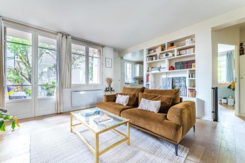 a living room with a couch and a table at Appartement Cosy avec Jardin in Saint-Cloud