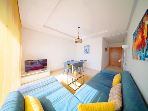 - un salon avec un canapé bleu et une table dans l'établissement AgadirBay, à Agadir