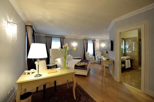 a living room with a table with a lamp and a couch at Hotel Palazzo San Lorenzo & Spa in Colle Val D'Elsa