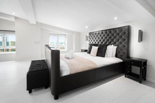 a bedroom with a large bed with a black headboard at Duplex Penthouse Apartment - Birmingham City Centre - Secure Parking - Terrace 1401M in Birmingham