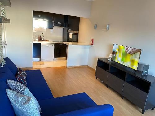 a living room with a blue couch and a kitchen at Columbano's House - Apartment in Central Lisbon in Lisbon