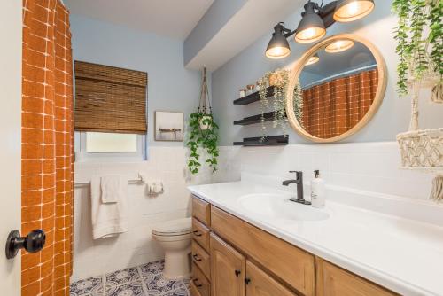 a bathroom with a sink and a toilet and a mirror at Luxury Home with Hot Tub & Outdoor Oasis blocks from the Beach in St Pete Beach