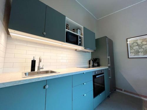 - une cuisine avec des placards bleus et un évier dans l'établissement Elegant house, Stockholm, à Stockholm