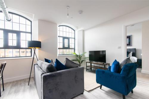 a living room with two blue chairs and a television at Modern 1 Bedroom Apartment Near Nottingham Train Station in Nottingham