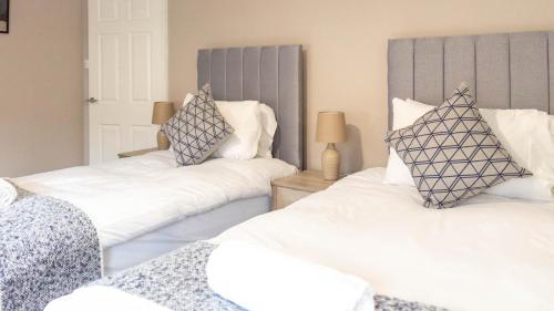 two beds with white sheets and pillows in a room at Airth House in Airth