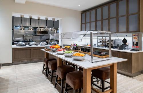 a kitchen with a table with bowls of food on it at Hilton Garden Inn Winnipeg South in Winnipeg