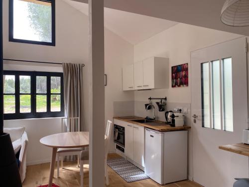 a small kitchen with white cabinets and a table at Studio de l'oliveraie in Aix-en-Provence