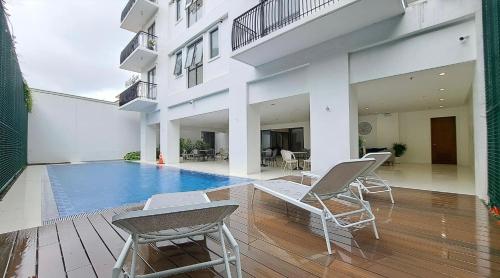 a house with a swimming pool and two chairs at Primo Condo Studio Type - One Pontefino Tower in Batangas City