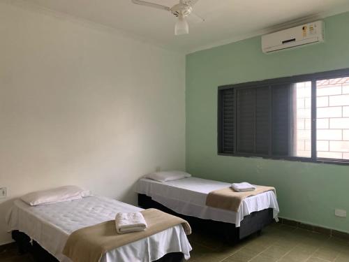 two beds in a room with a window at Hostel Araucaria in Ribeirão Preto