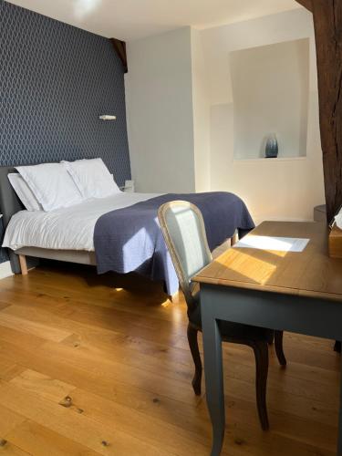 a bedroom with a bed and a desk and a table at Le Clos d 'Aÿ in Épernay