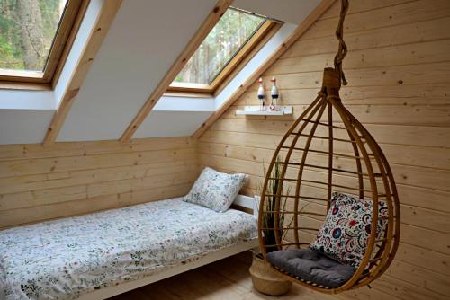 a room with a swing and a bed in a attic at Leśniczówka Białogóra in Białogóra