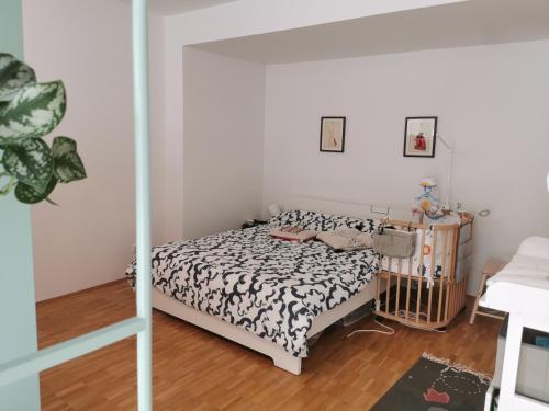 een slaapkamer met een bed met een zwart-wit dekbed bij Center Schwabing Spacious flat in München