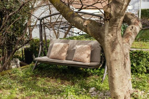 a couch sitting in the grass next to a tree at Step to Kotor bay St-oliv in Kotor