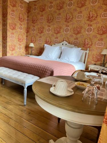 a bedroom with a bed and a table with a coffee table at Le Clos d 'Aÿ in Épernay