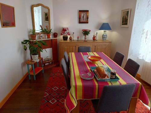 a dining room with a table with a colorful table cloth at ArPaMond in Château-Chinon