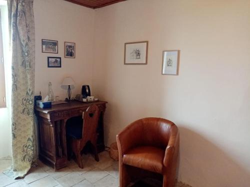 una silla sentada junto a un escritorio en una habitación en Le Clos Saint Georges, en Donnazac