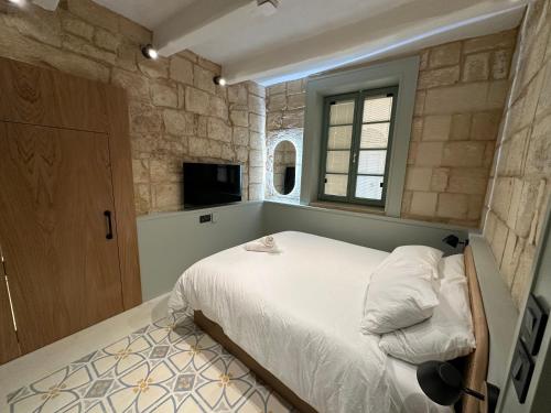 a bedroom with a white bed and a window at Lorenzo x Casa Norte in Birgu
