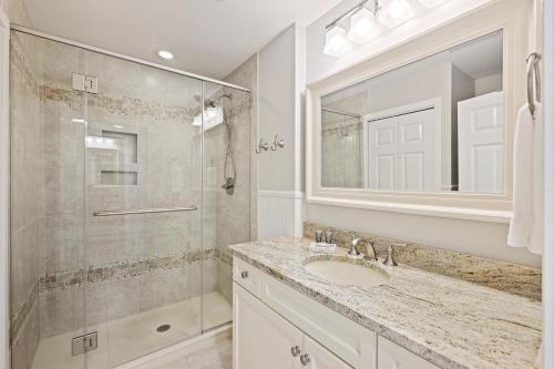a bathroom with a shower and a sink and a mirror at 8A Seagrove Villa in Isle of Palms