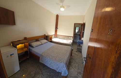a small bedroom with a bed and a dresser at Fazenda do Prata Ecoresort in Caratinga