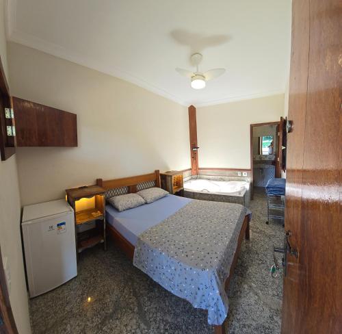 a small bedroom with a bed and a table at Pousada Fazenda do Prata Ecoresort in Caratinga