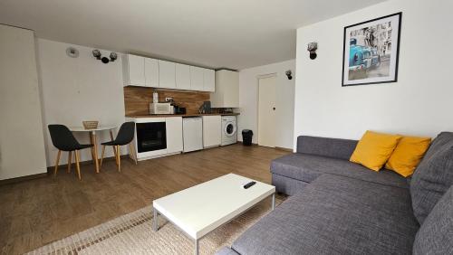 a living room with a couch and a table at CosyNook - refait à neuf proche parc des expositions et aéroport CDG - Parking privé gratuit in Villepinte