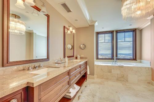 a bathroom with two sinks and a tub and a large mirror at Ski-InandSki-Out Condo in Park City with 6 Balconies! in Park City