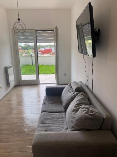 a couch sitting in a living room with a tv at Emanuele House in Porto