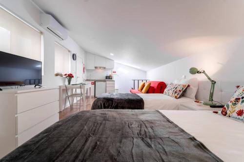 Habitación blanca con 2 camas y cocina en Praça Velha II - Estúdio no Centro de Braga, en Braga