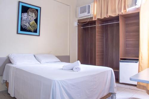 um quarto com uma cama branca com uma toalha em Prestige Manaus Hotel em Manaus