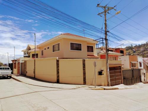 昆卡的住宿－Casa Quirola hermosa y muy grande，前面有栅栏的黄色房子