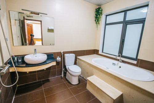 Villa Ngọc Trai - NT75 FLC Sầm Sơn في سام سون: حمام مع حوض ومرحاض وحوض استحمام