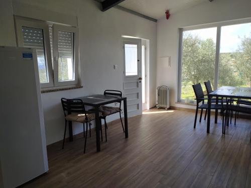 a dining room with tables and chairs and windows at Vivenda das Eiras in Vale de Porco