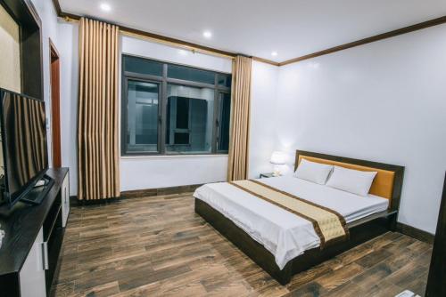 ein Schlafzimmer mit einem Bett und einem großen Fenster in der Unterkunft Villa Ngọc Trai - NT75 FLC Sầm Sơn in Sầm Sơn