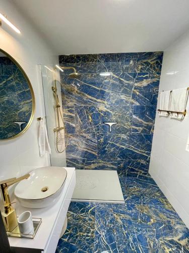 a bathroom with a sink and a blue marble wall at Holiday Home Zagorka in Ogulin