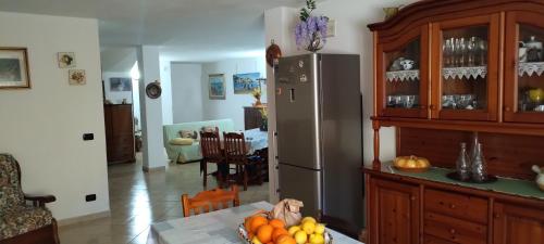 a kitchen with a refrigerator and a table with fruit at Taverna Cristina in Porto Torres