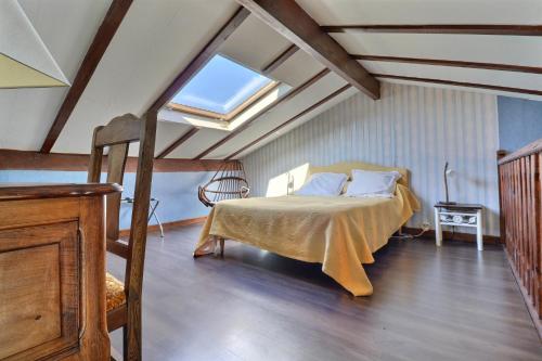 ein Schlafzimmer mit einem Bett im Dachgeschoss mit einem Fenster in der Unterkunft Domaine de Hurlevent in Montgaillard-Lauragais