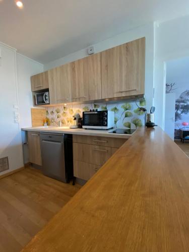 une cuisine avec des placards en bois et un comptoir en bois dans l'établissement Horizon sur le Cher, à Montrichard