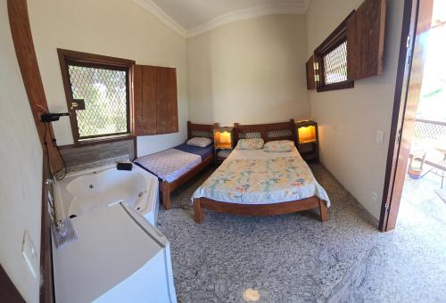a bedroom with two beds and a bath tub at Fazenda do Prata Ecoresort in Caratinga