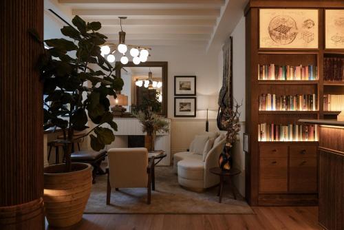 a living room with a couch and a chair and a plant at Hotel Pulitzer Paris in Paris