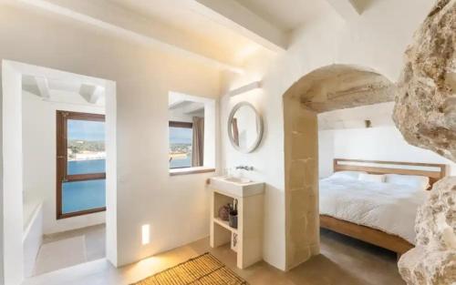 a bedroom with a bed and a sink and a mirror at Triplex lujo Mahón vistas espectaculares in Mahón