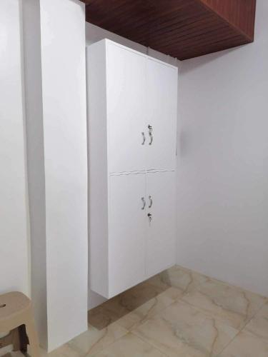 Habitación blanca con armarios blancos y techo de madera. en RYO3 en Dávao