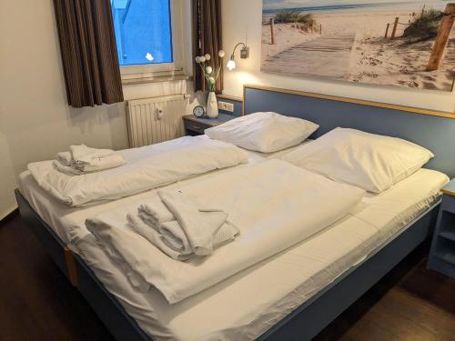キュールングスボルンにあるYachthafenresidenz-Wohnung-8404-866のベッド(白いシーツ、タオル付)