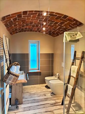a bathroom with a toilet and a glass shower at LOCANDA VECCHIO NOVECENTO in Grosso