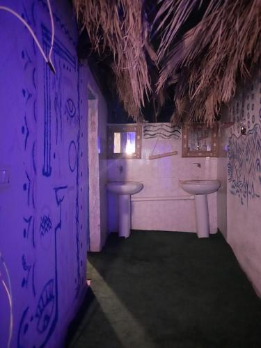 a bathroom with two sinks and a purple wall at Perry’s Island Camp Al Mezina in Nuweiba