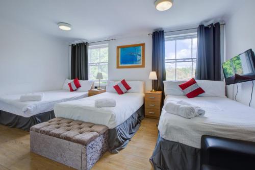 ein Hotelzimmer mit 3 Betten und einem Sofa in der Unterkunft Lamont Hotel in London